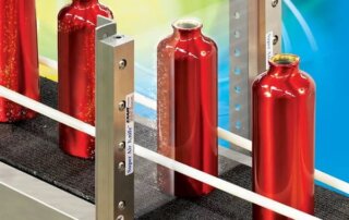 Super Air Knives blasen rote Flaschen in einer Abfüllanlagen ab.